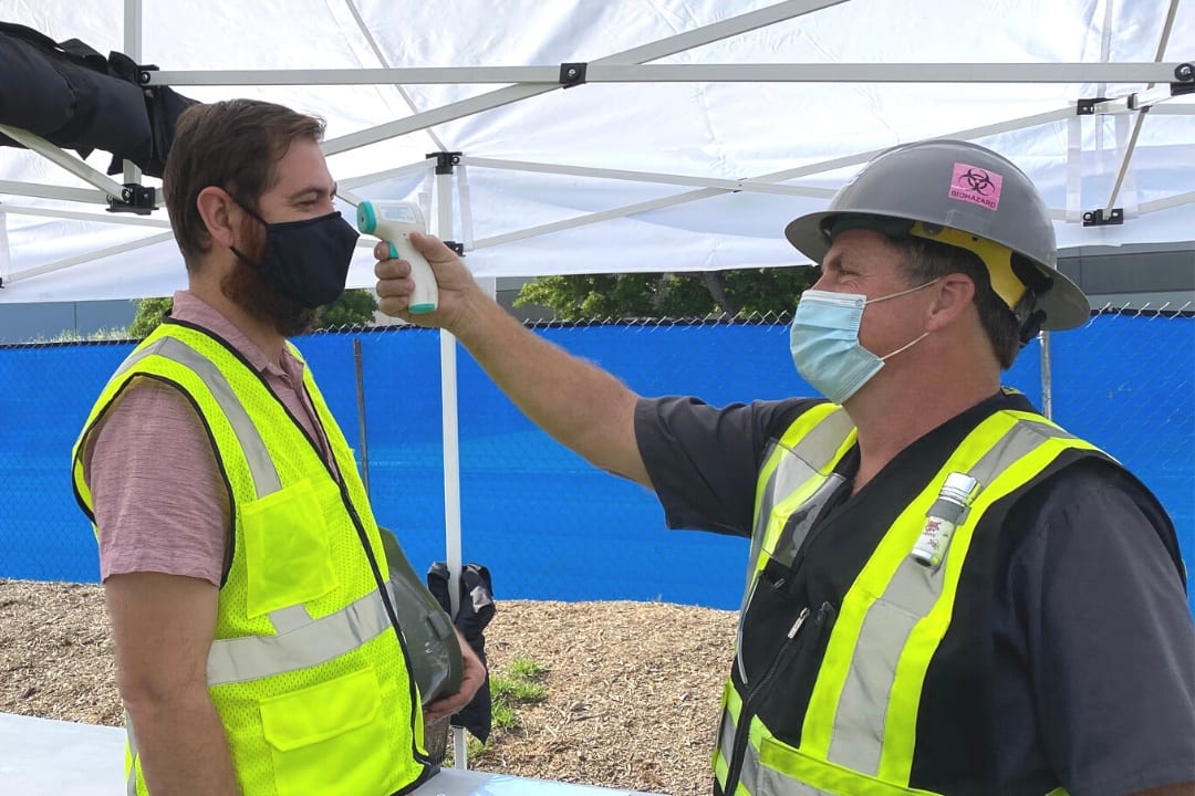 Employee gets temperature checked at job site